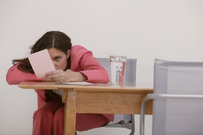 Upset businesswoman staring at pink slip